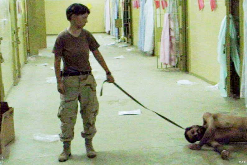 Amateurfoto aus Abu Ghoraib, auf dem ein Gefangener misshandelt wird.